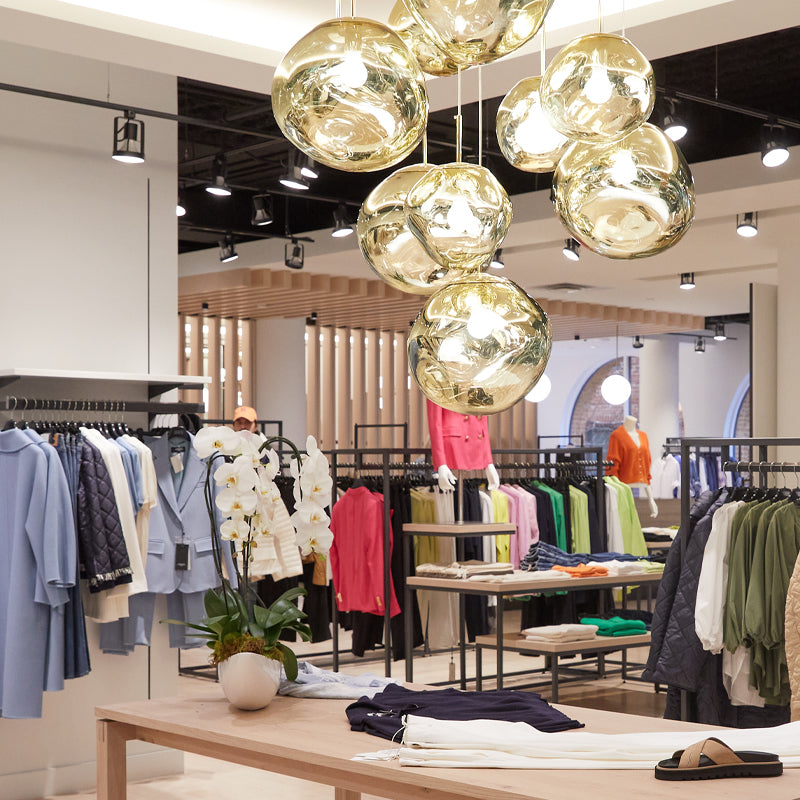 In-store view of Yorkville village, display of various clothing and gold chandelier. 