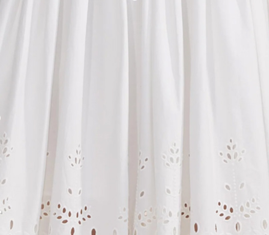 Close-up view of white cotton fabric, showcasing its smooth texture and crisp appearance.  